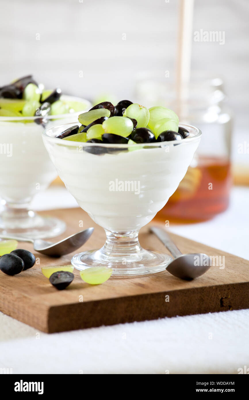 Couple of glasses of greek yogurt with red and white grapes Stock Photo Alamy