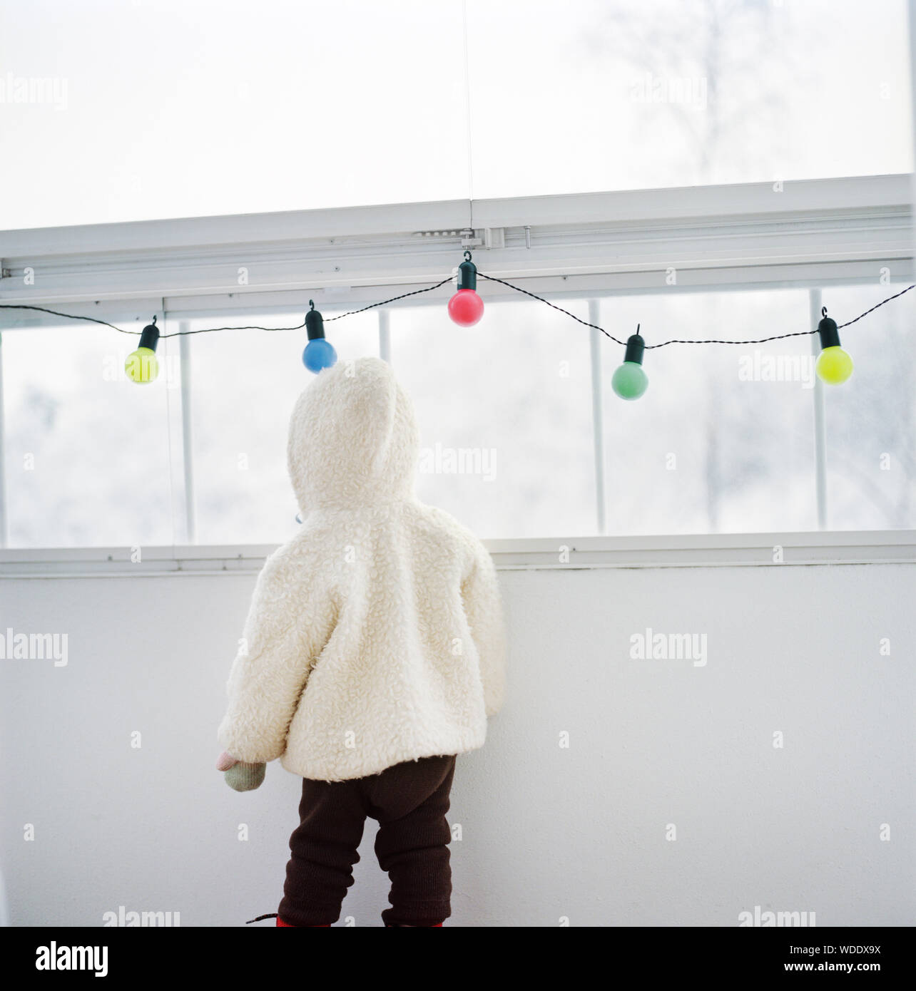 Rear view of child wearing warm clothes indoors Stock Photo