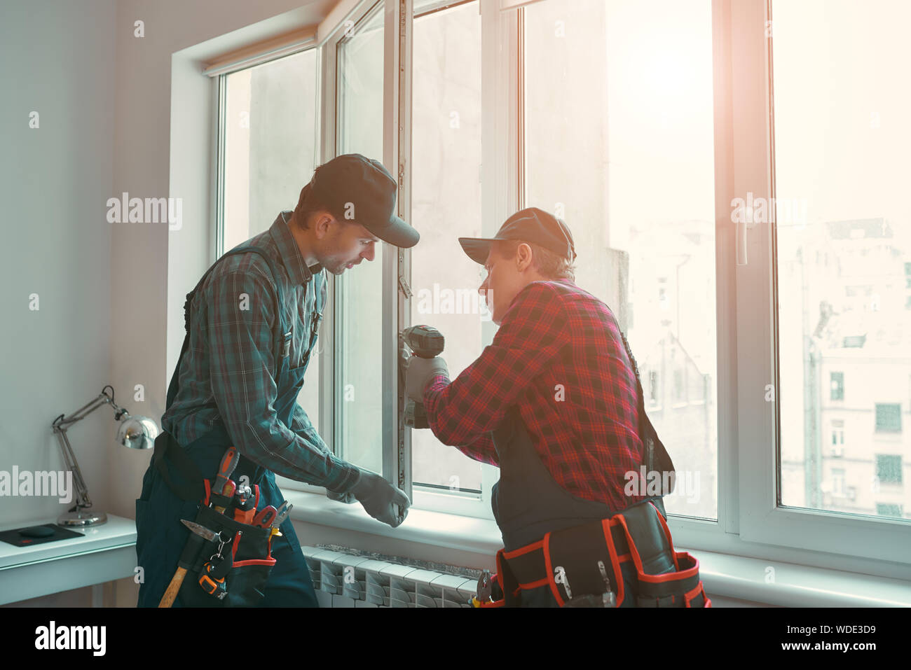 Portrait of mature men wearing uniform standing indoors and installing ...