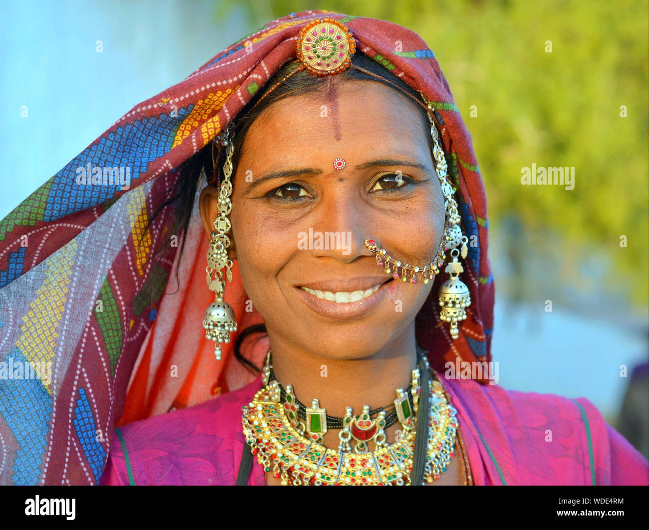 Beautiful Indian Rajasthani gypsy woman in traditional tribal attire and jewellery smiles for the camera. Stock Photo