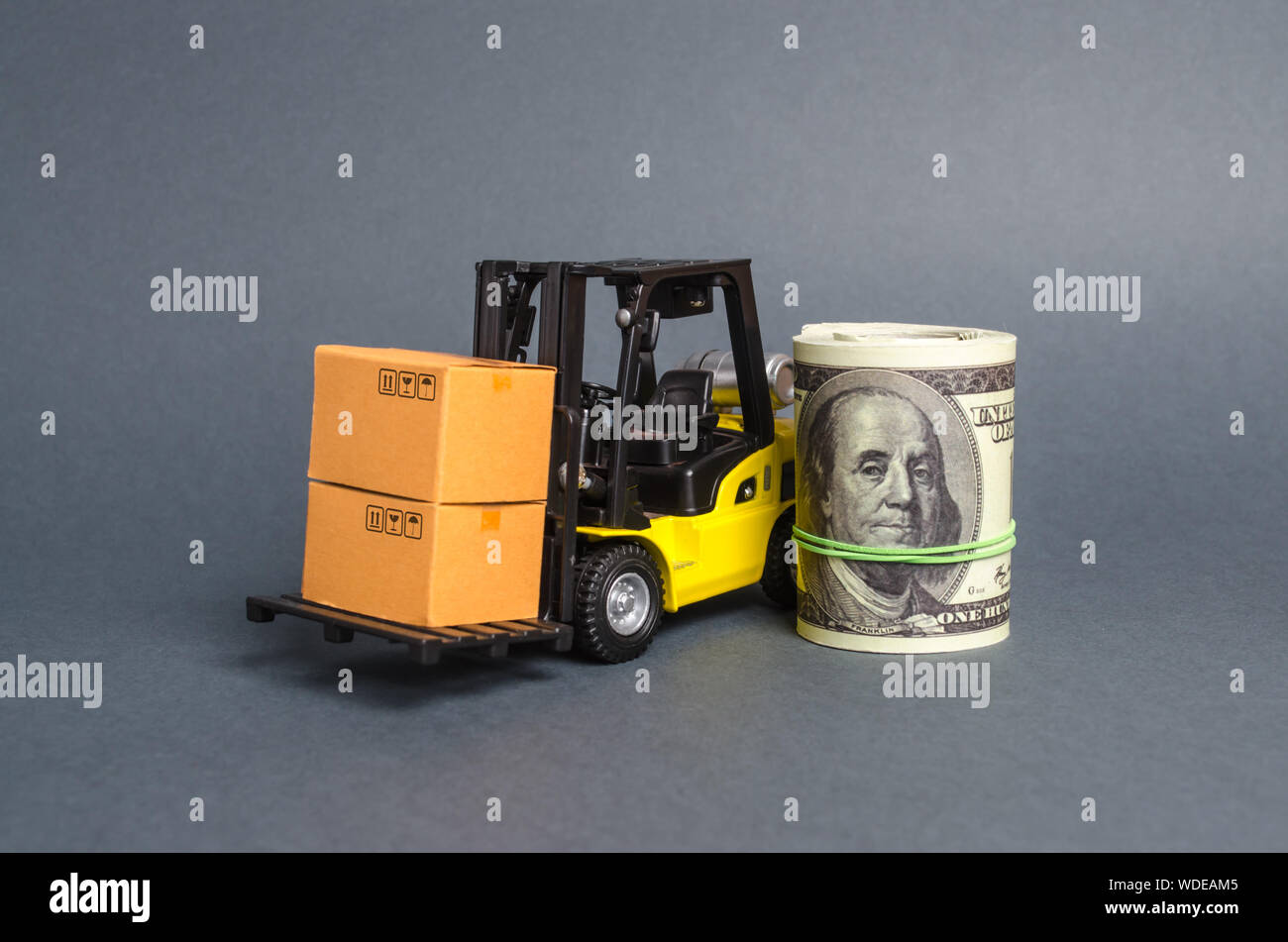A forklift truck carries cardboard boxes and dollar roll. Transport company. Performance efficient. Trade and production of products and goods, balanc Stock Photo