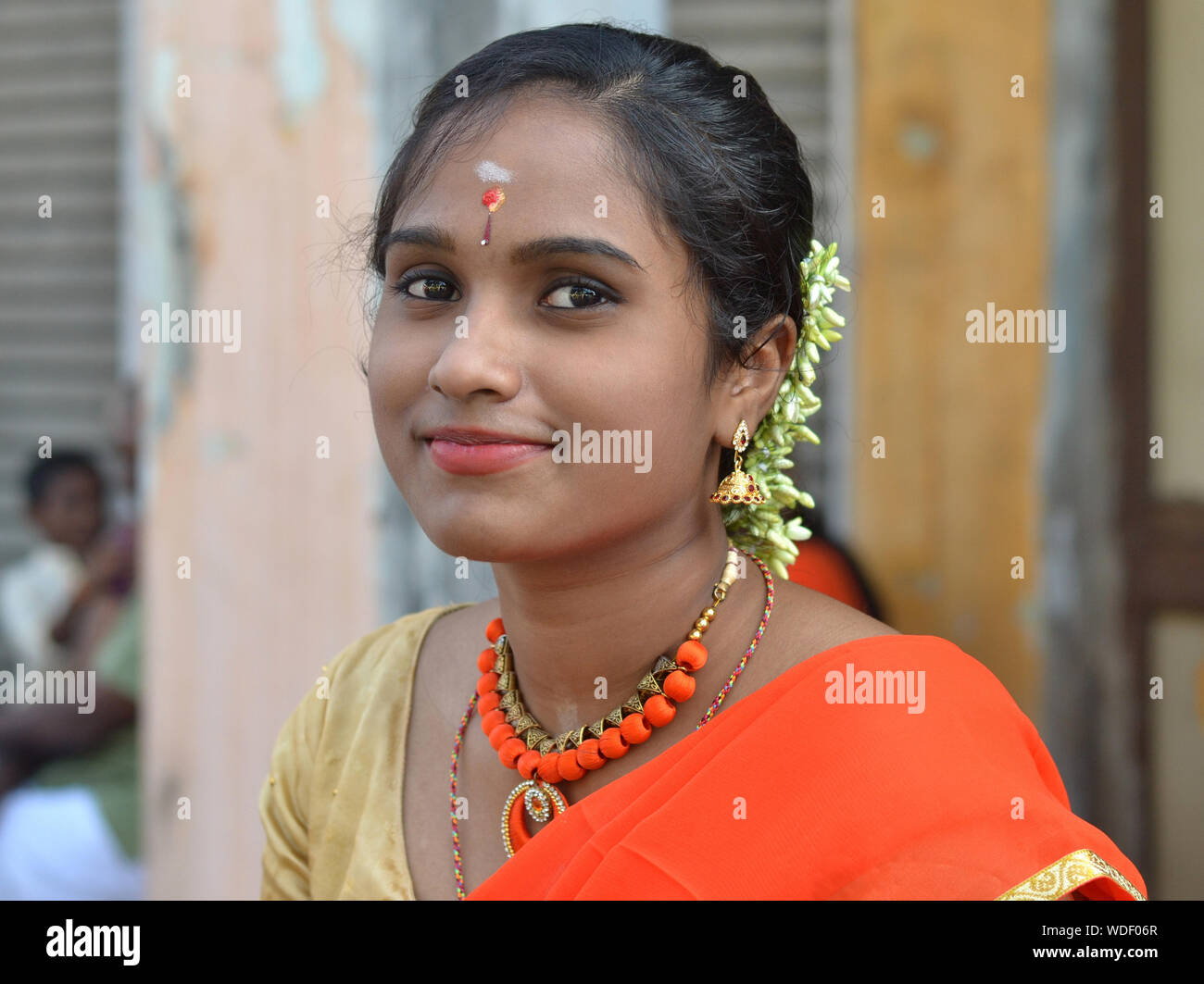 Beautiful young Malaysian Indian woman with flowers in her hair poses for the camera during Thaipusam. Stock Photo