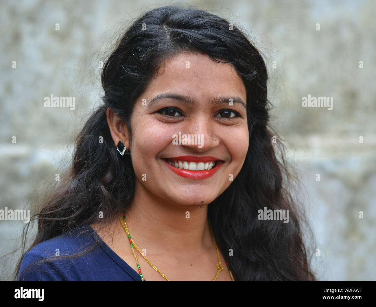 Beautiful young Nepali Hindu woman with lipstick smiles for the camera. Stock Photo
