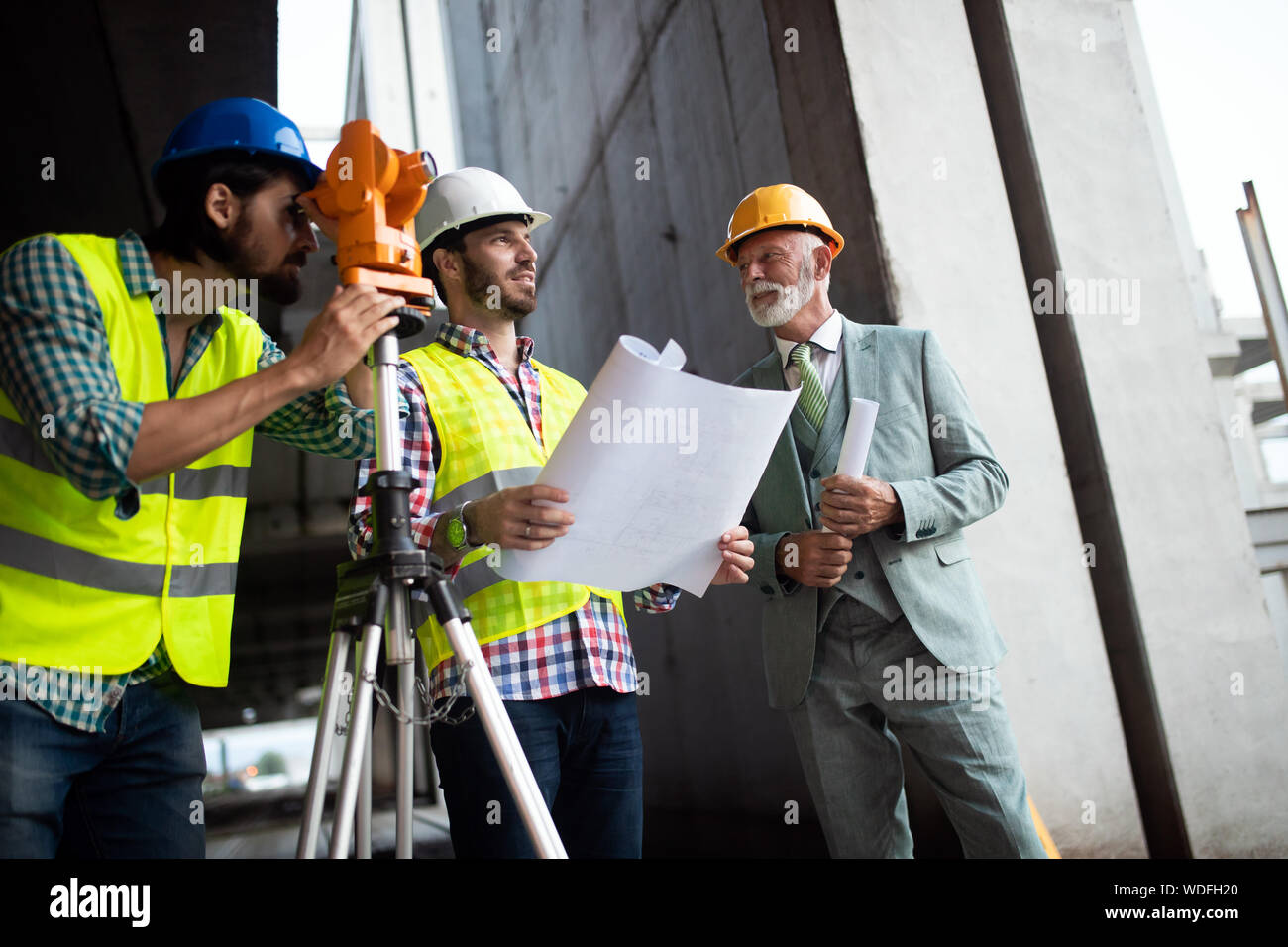 Engineer, foreman and worker discussing in building construction site Stock Photo