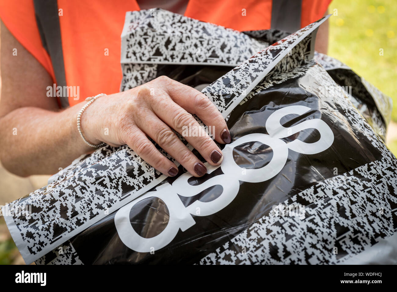 A woman delivering a package from asos, the online fashion clothing website Stock Photo