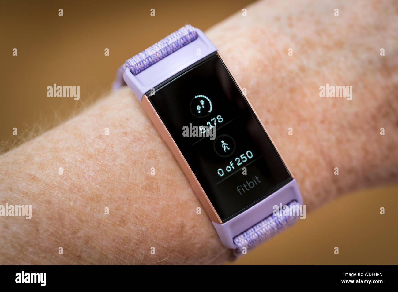 A woman looking at her steps count on a Fitbit Charge 3 fitness tracker watch Stock Photo