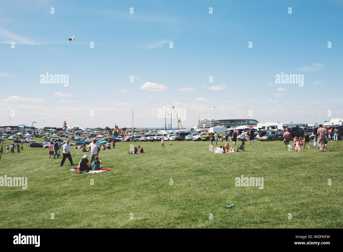 People On Field At Epsom Downs Racecourse Against Sky Stock Photo