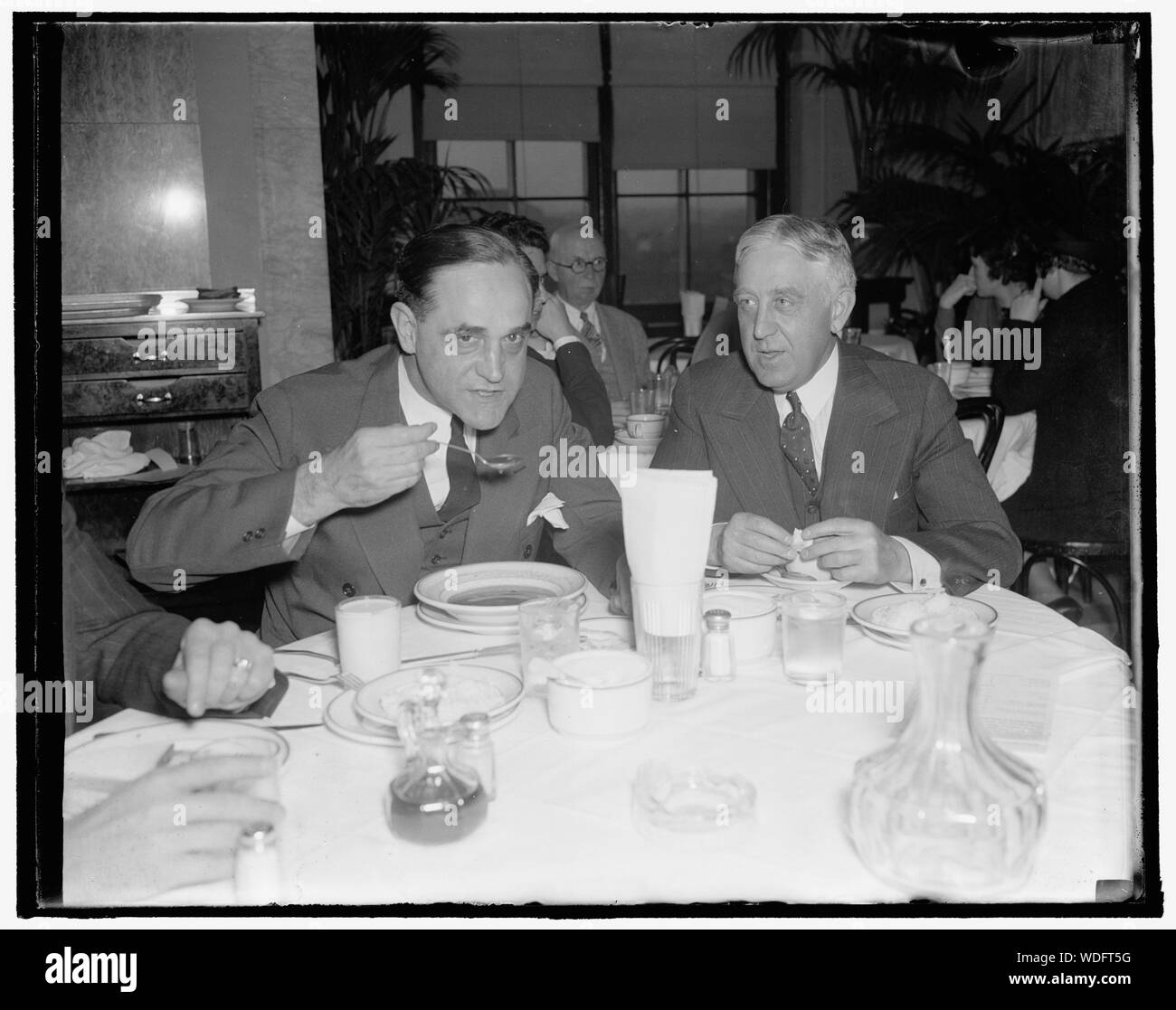 Gentlemen from Indiana. Washington, D.C., Nov. 15. Democratic Senator Sherman Minton of Indiana, takes time out at the opening of the special session to enjoy a bit of lunch in the Capitol restaurant. 11/15/37 Abstract/medium: 1 negative : glass  4 x 5 in. or smaller Stock Photo