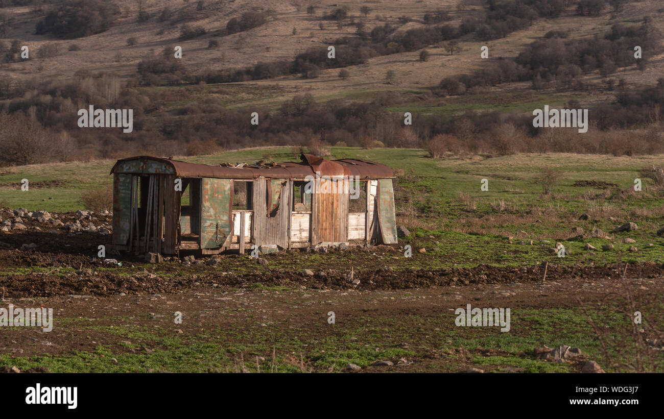 abandoned train carriage somewhere in Georgia (country), on a field in the afternoon, spring time Stock Photo