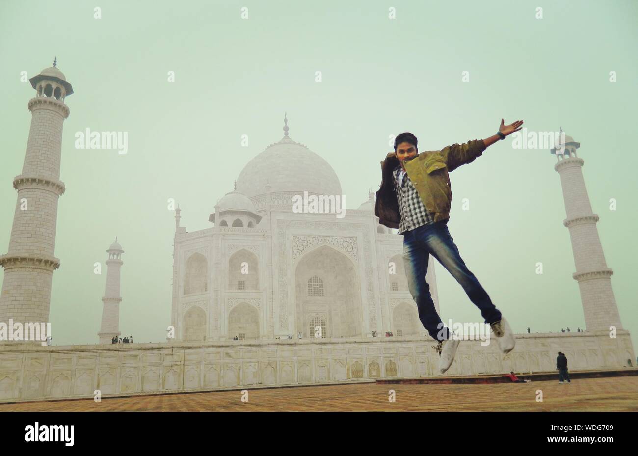 Excited Young Man Jumping Against Taj Mahal Stock Photo - Alamy