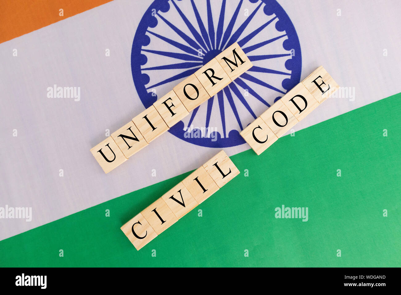 Concept of One law for all called Uniform Civil code or UCC in Indian constitution in wooden block letters on Indian flag. Stock Photo