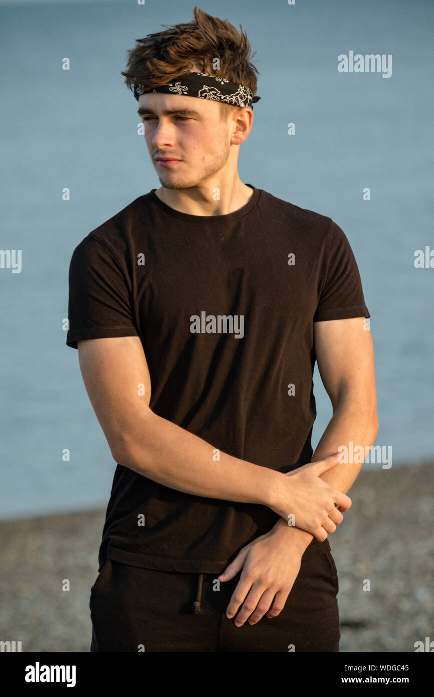 Young male adult portrait at golden hour on a beach Stock Photo