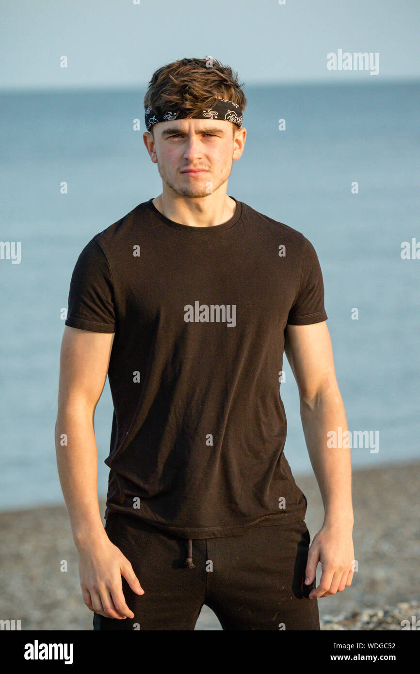 Young male adult portrait at golden hour on a beach Stock Photo