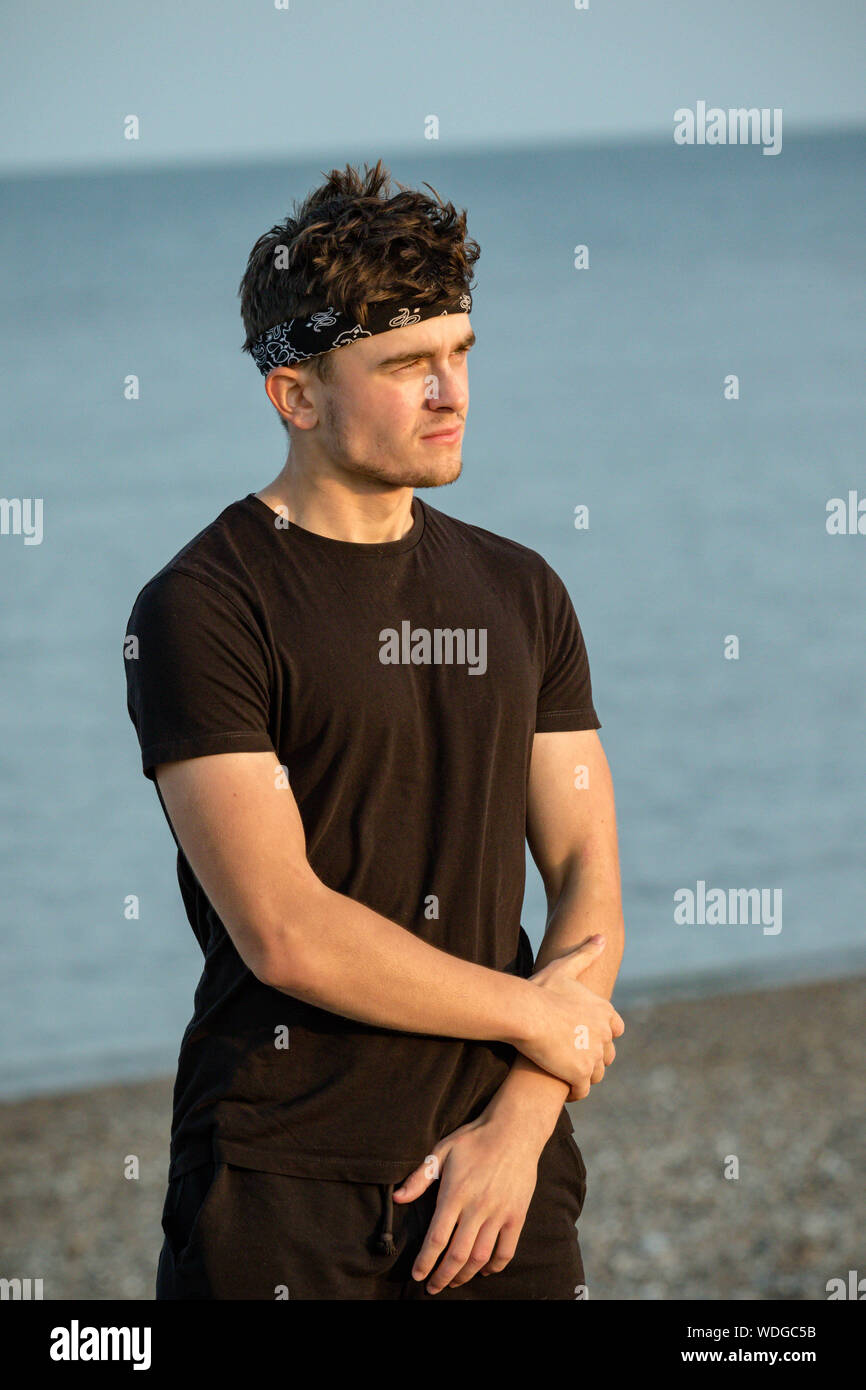 Young male adult portrait at golden hour on a beach Stock Photo