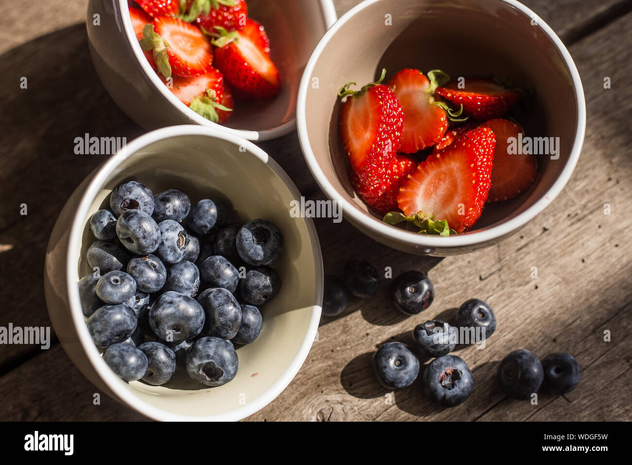 Blackberry and strawberry in bowl over wooden background. Close up, top view, high resolution product. Harvest Concept Stock Photo