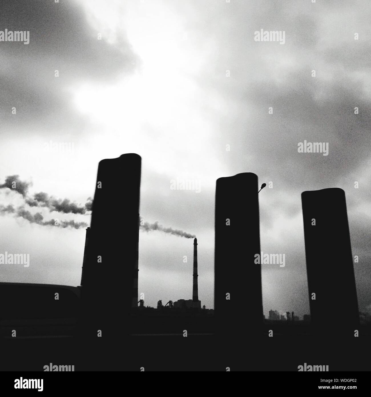 Low Angle View Of Factory With Smoke Stack Emitting Pollution Stock Photo