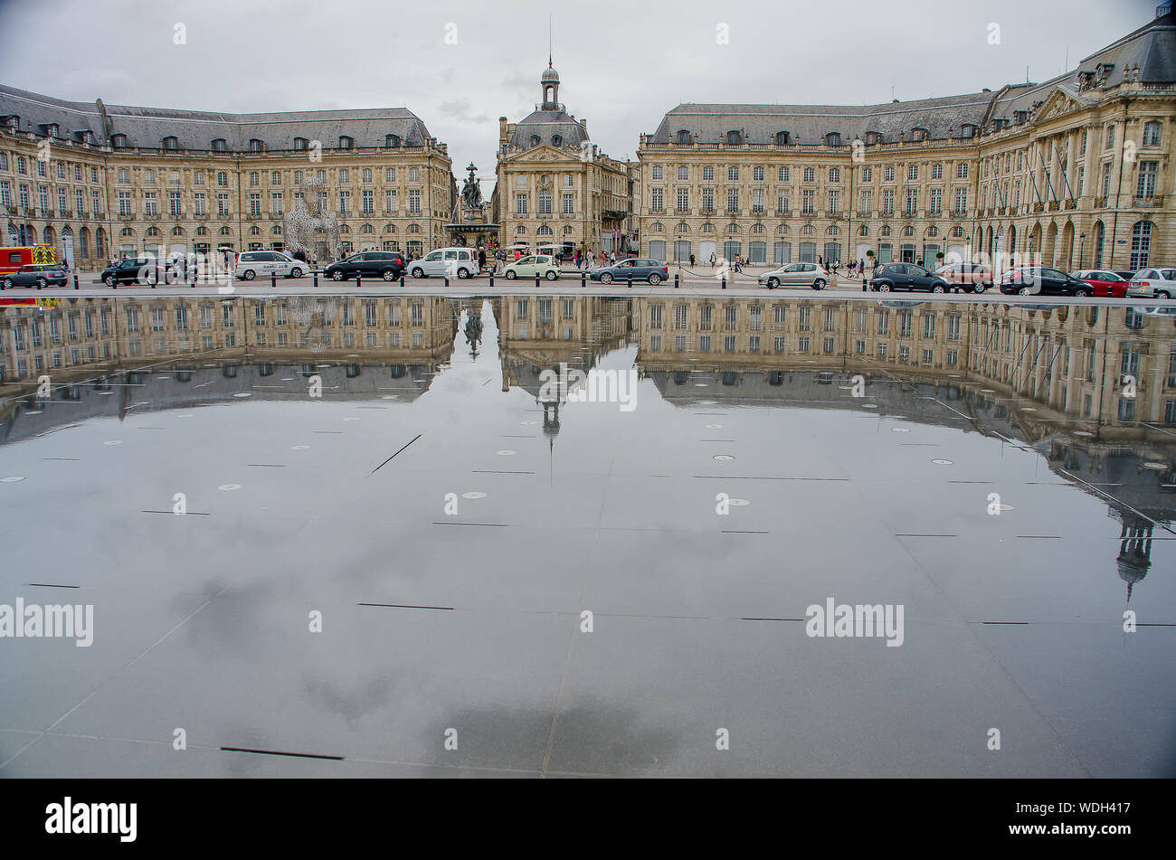 Reflection of neoclassical buildings in the water mirror of the Place de la Bourse de Bordeaux Stock Photo