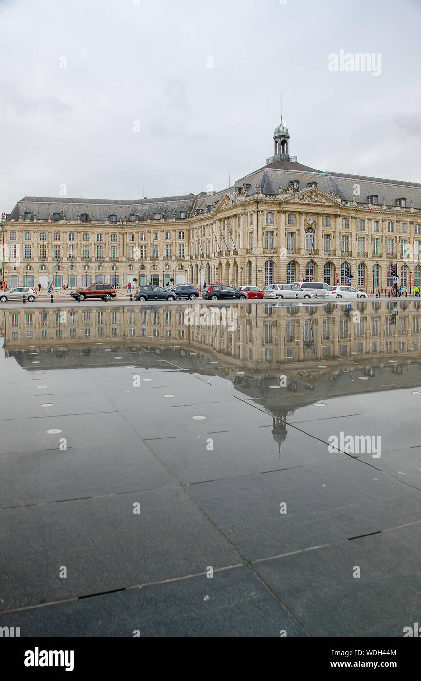 Reflection of neoclassical buildings in the water mirror of the Place de la Bourse de Bordeaux Stock Photo
