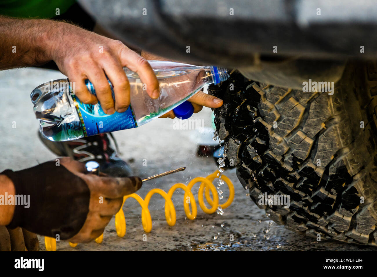 Expedition style tire repair on the Silk Road in Murghab, Tajikistan.  Compressor, water bottle, drill and a vulcanizable rubber thread are enough  for the tire to last another 1,000 kilometers on gravel