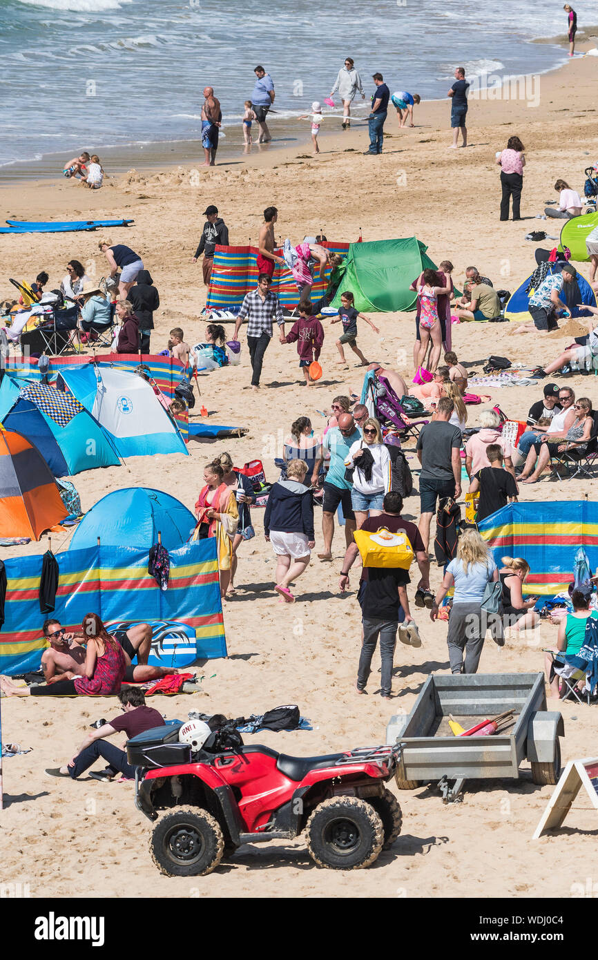 Holidaymakers on a staycation holiday enjoying themselves on Fistral Beach in Newquay in Cornwall. Stock Photo