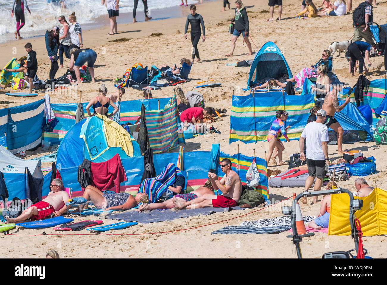 Holidaymakers enjoying themselves on Fistral Beach in Newquay in Cornwall during the summer. Stock Photo