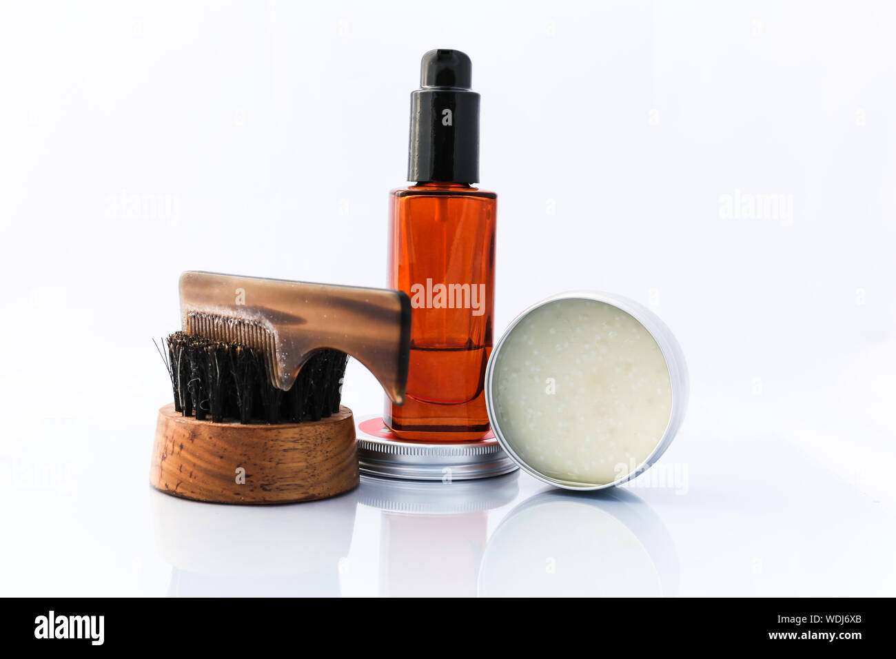 A selection of men's beard grooming products that include oil, wax and a brush, shot against a clean white background Stock Photo