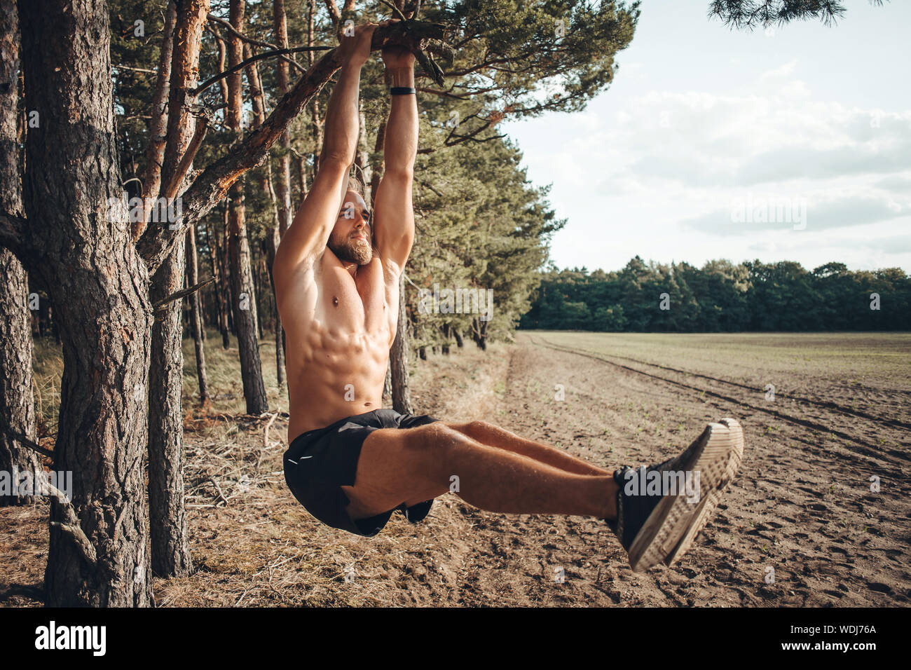 Man is training his abdominal muscles outdoors Stock Photo