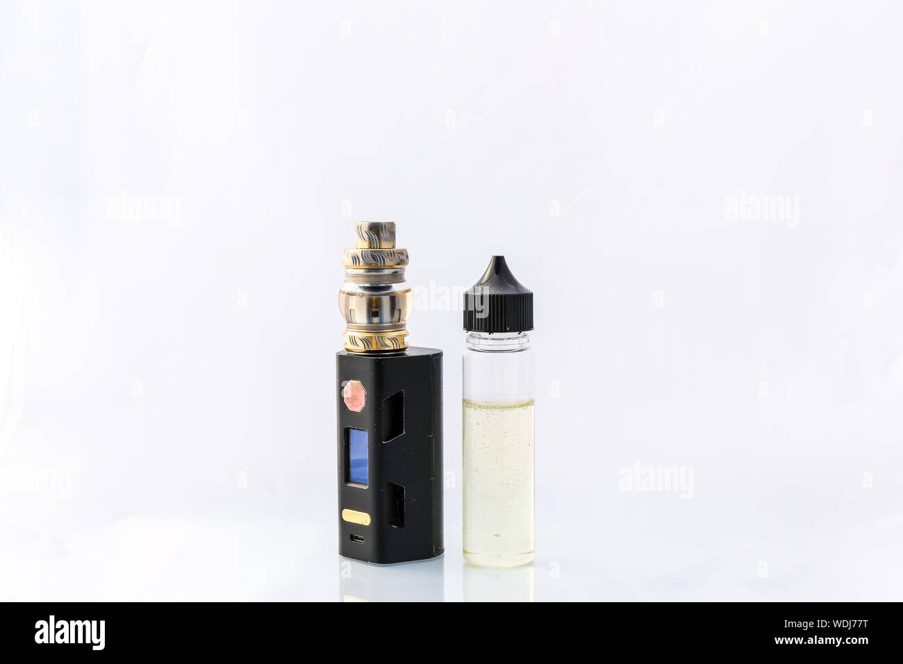 A electric cigarette vape deice with a bottle of liquid stood next to it. Shot against a clean white background Stock Photo