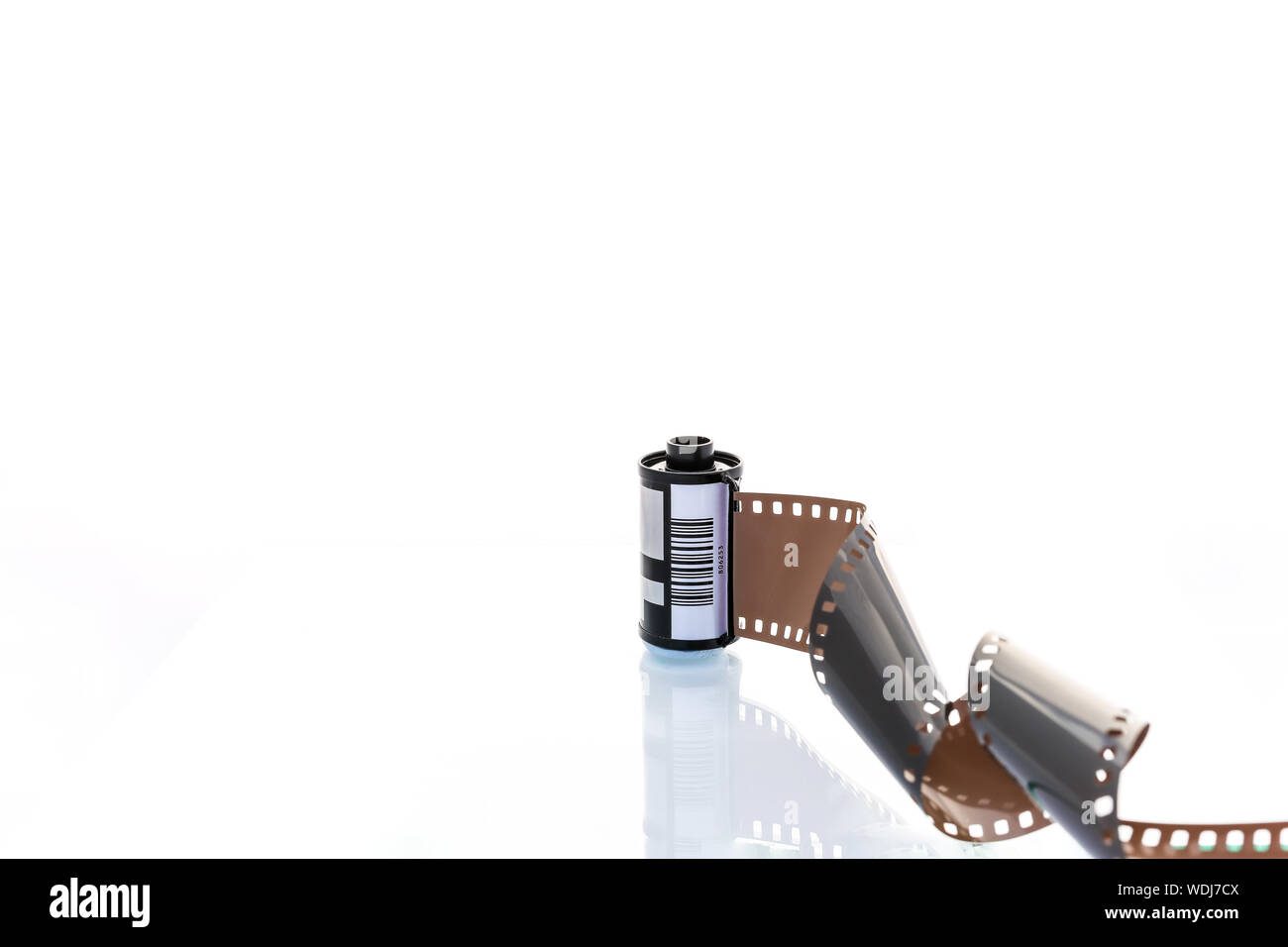 A roll of 35mm film unrolled and leading out towards the camera. Shot