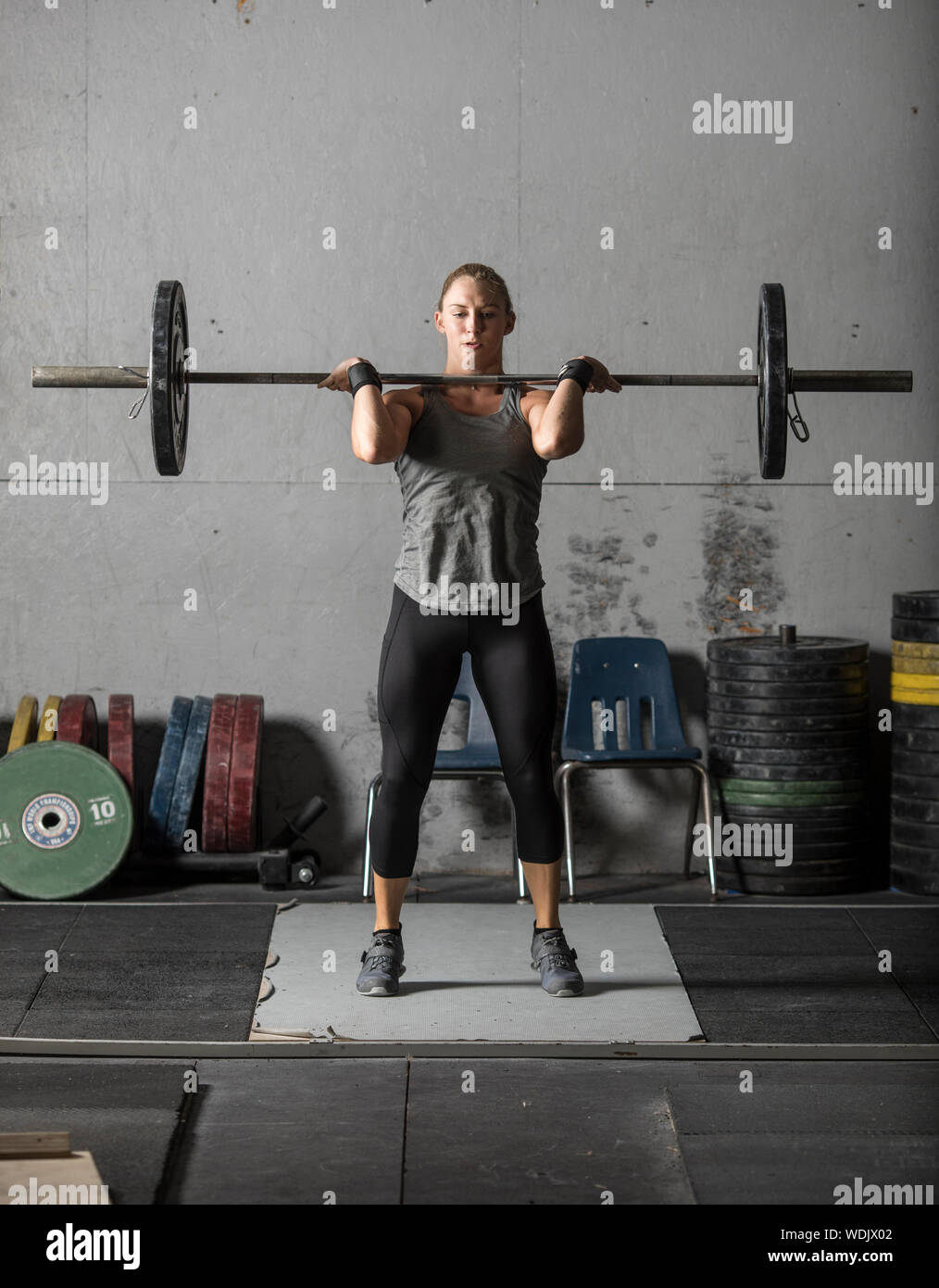 Female powerlifter doing a clean and jerk with heavy weights Stock