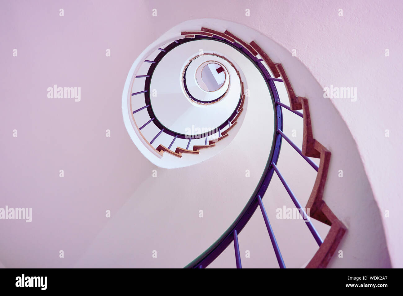 Spiral staircase viewed from below forming circular geometric pattern Stock Photo