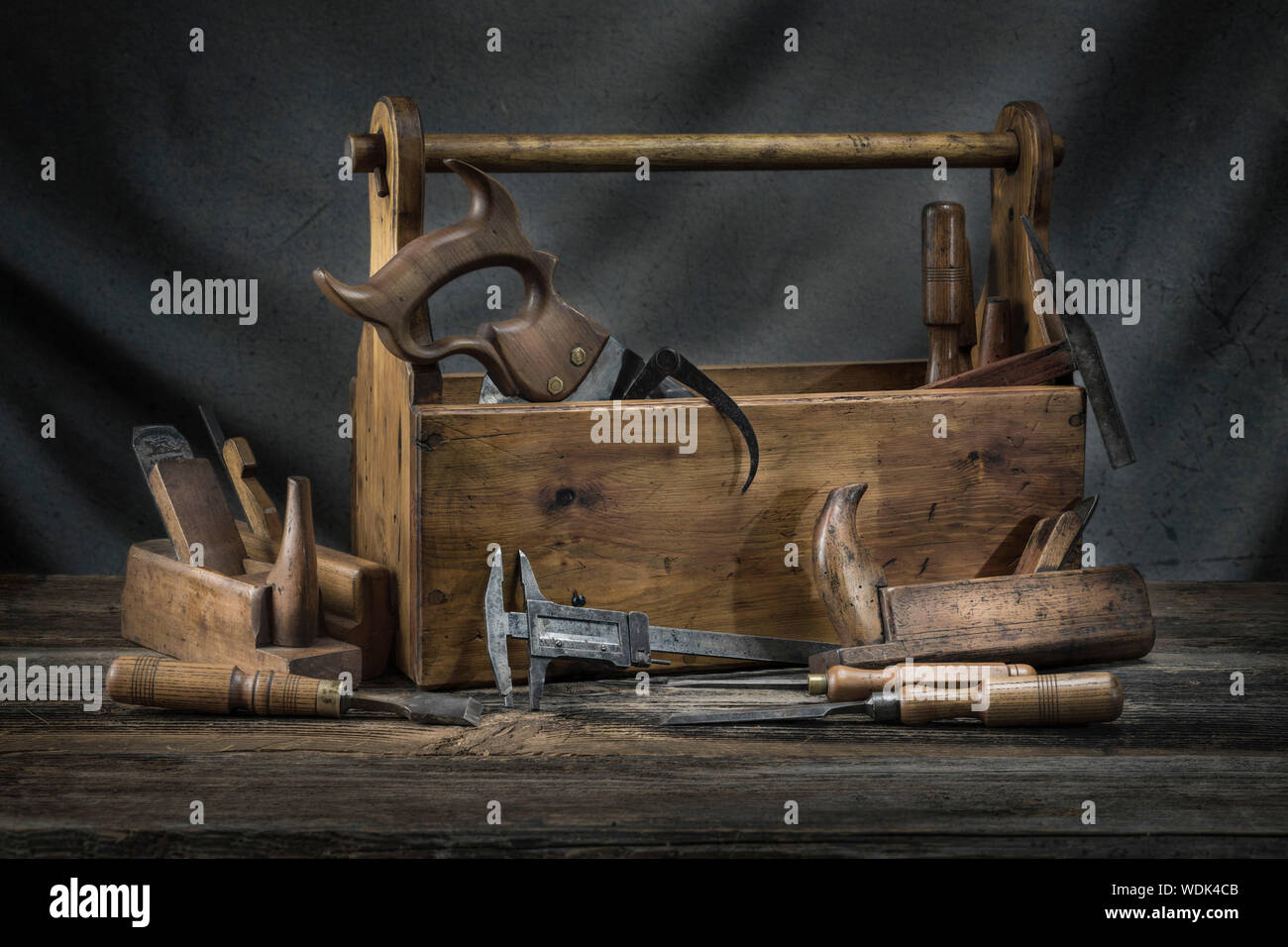 Still life - Old Wooden vintage toolbox with hammers, saw, chisels, plane and pliers in carpentry Stock Photo