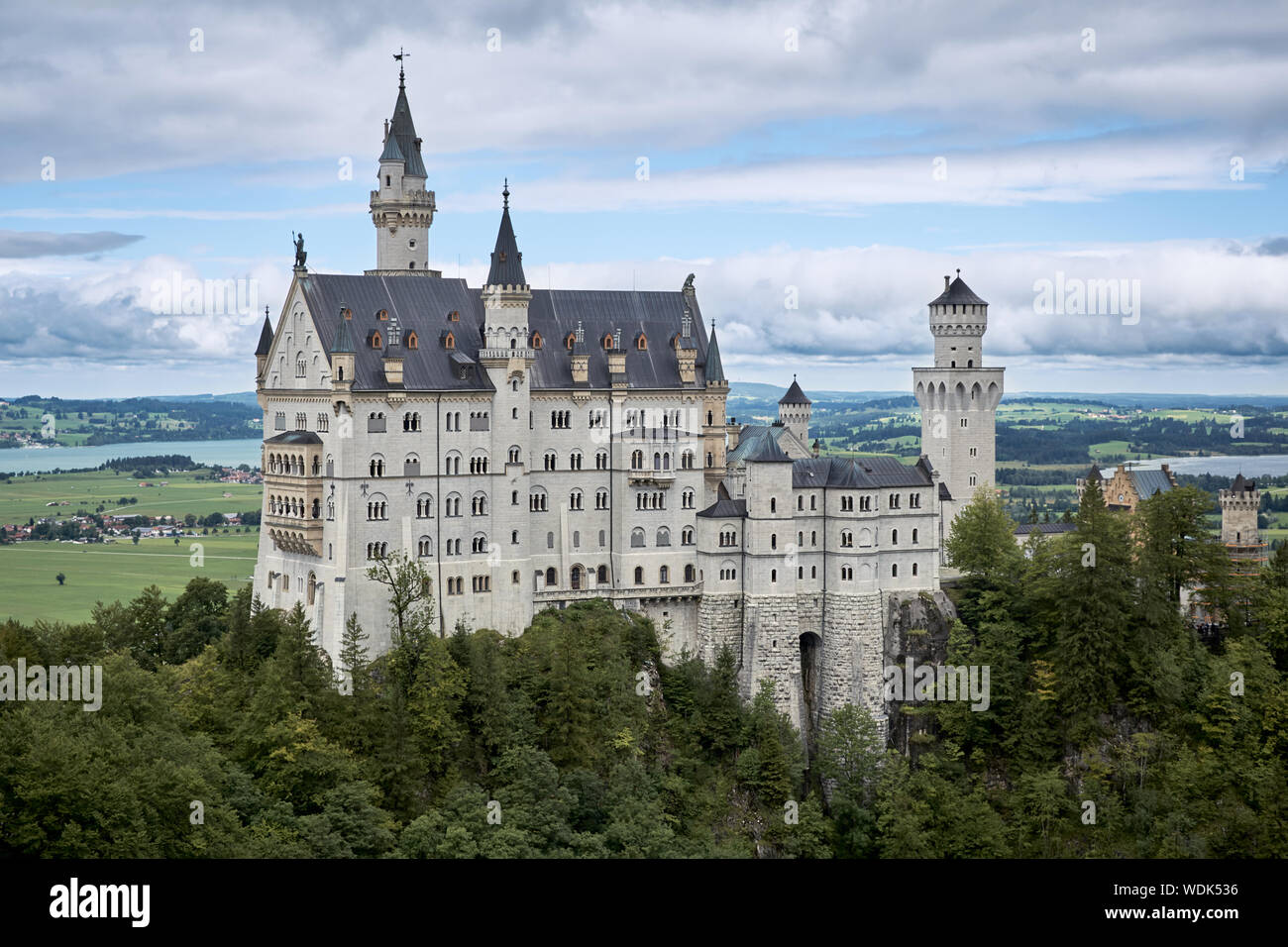 View of the famous tourist attraction in the Bavarian Alps - the Neuschwanstein castle infront of blue sky and nature / 2019 Stock Photo