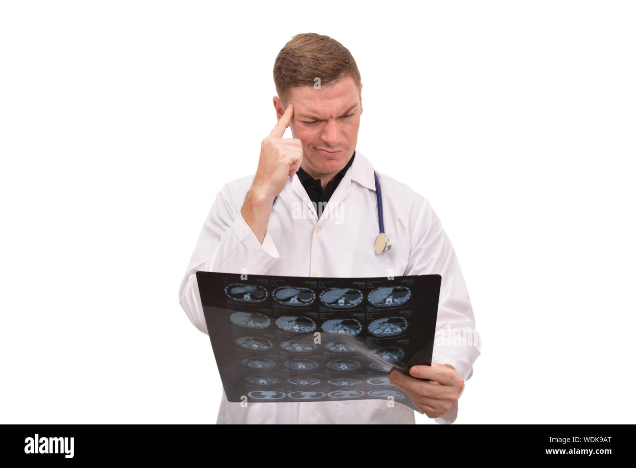 Confused Male Doctor Examining Mir Scan Against White Background Stock Photo