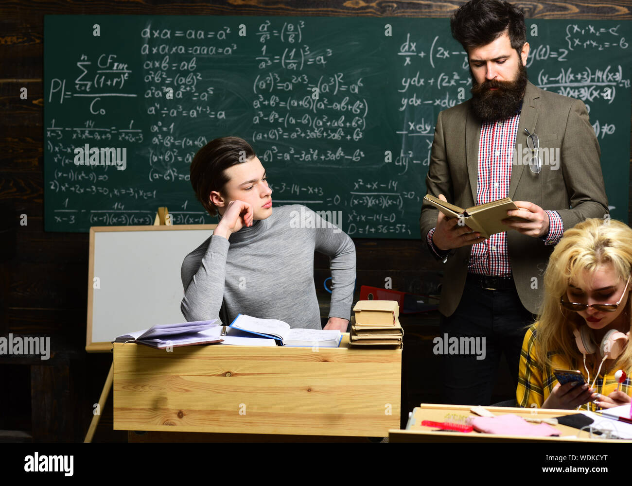 Students studying and testing lesson from teacher in classroom at ...