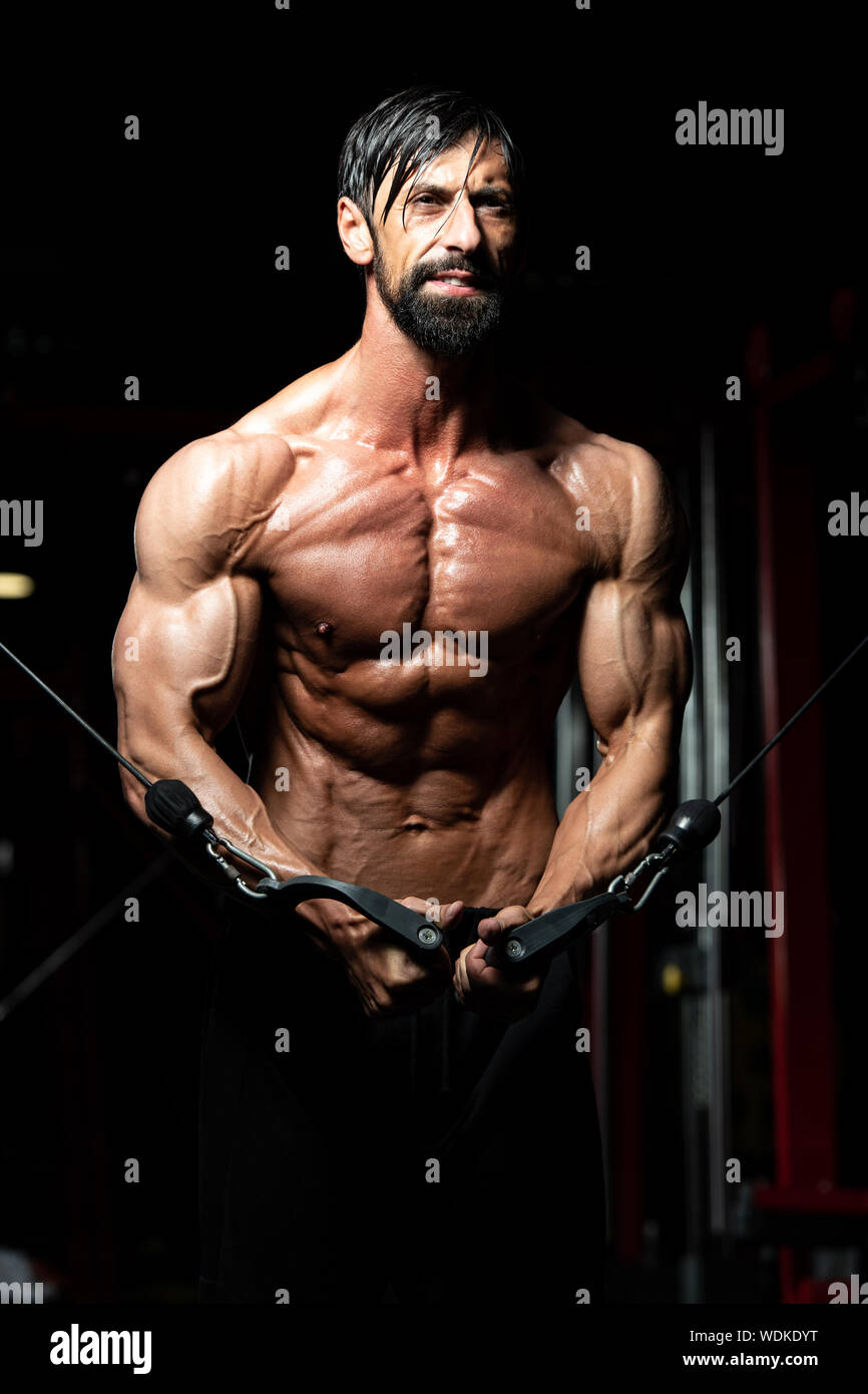 Handsome Muscular Fitness Bodybuilder Doing Heavy Weight Exercise For Chest  On Machine With Cable In The Gym Stock Photo - Alamy