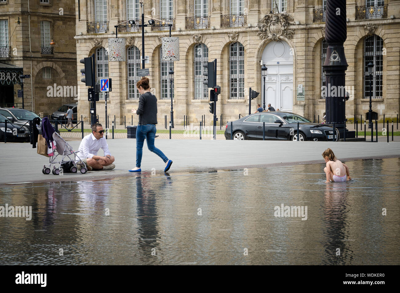 Little girl playing in the water mirror of the Place de la Bourse in Bordeaux. September 2013. France Stock Photo