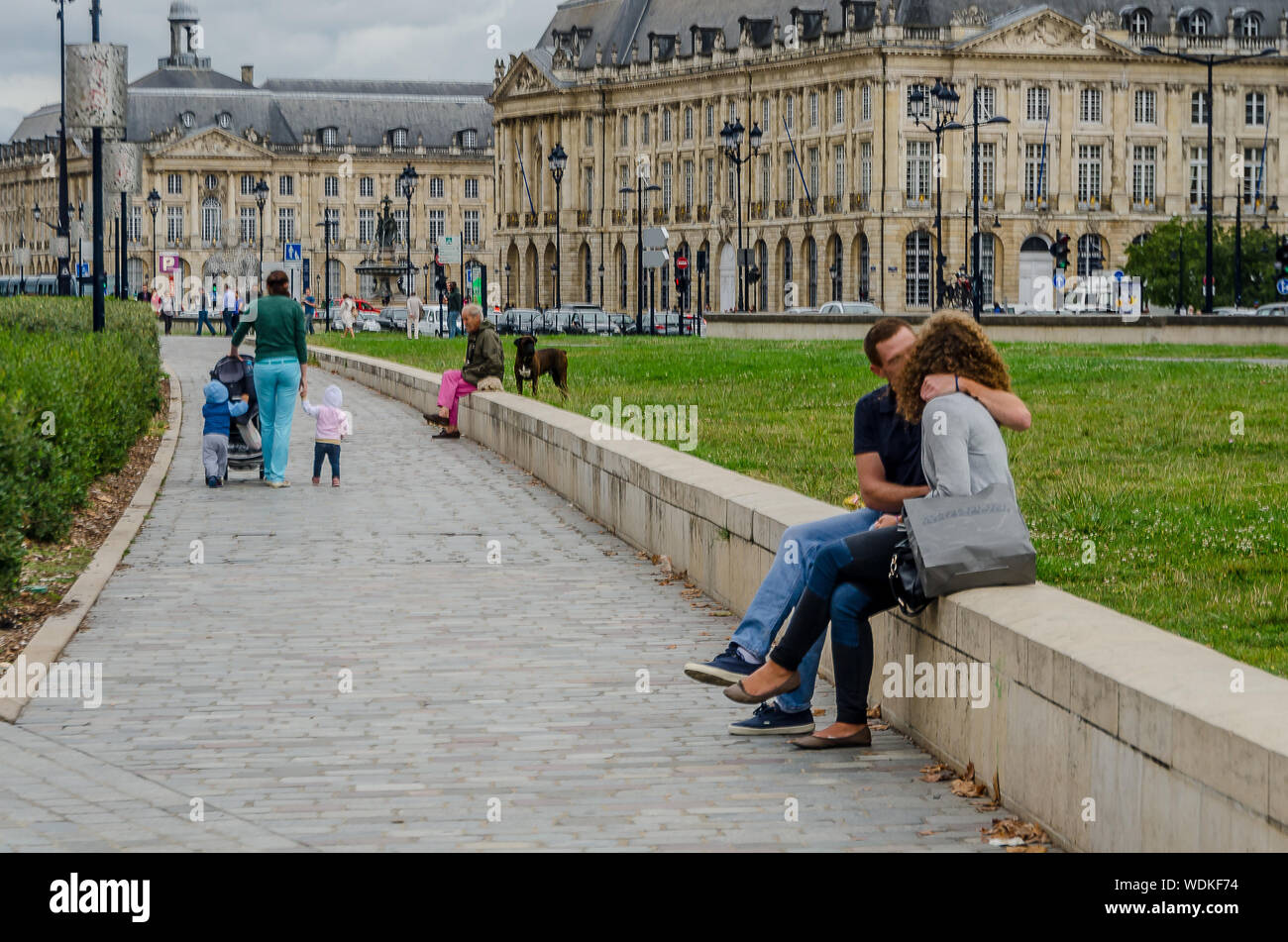 Couple of man and woman kissing in the Place de la Bourse in the city of Bordeaux, France, in September 2013 Stock Photo