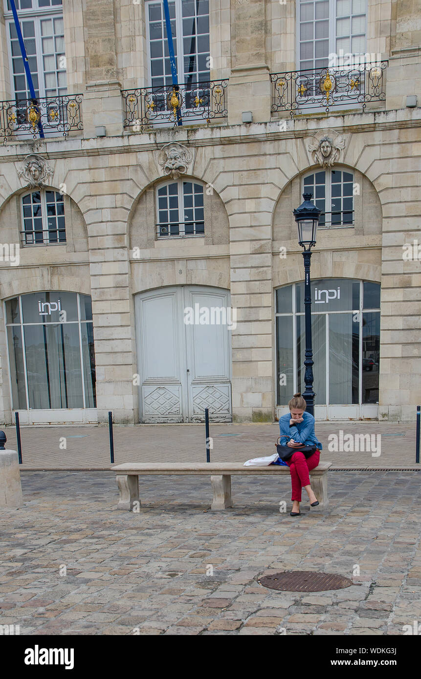 Woman reading sitting on a bench in Bordeaux, France, in September 2013 Stock Photo