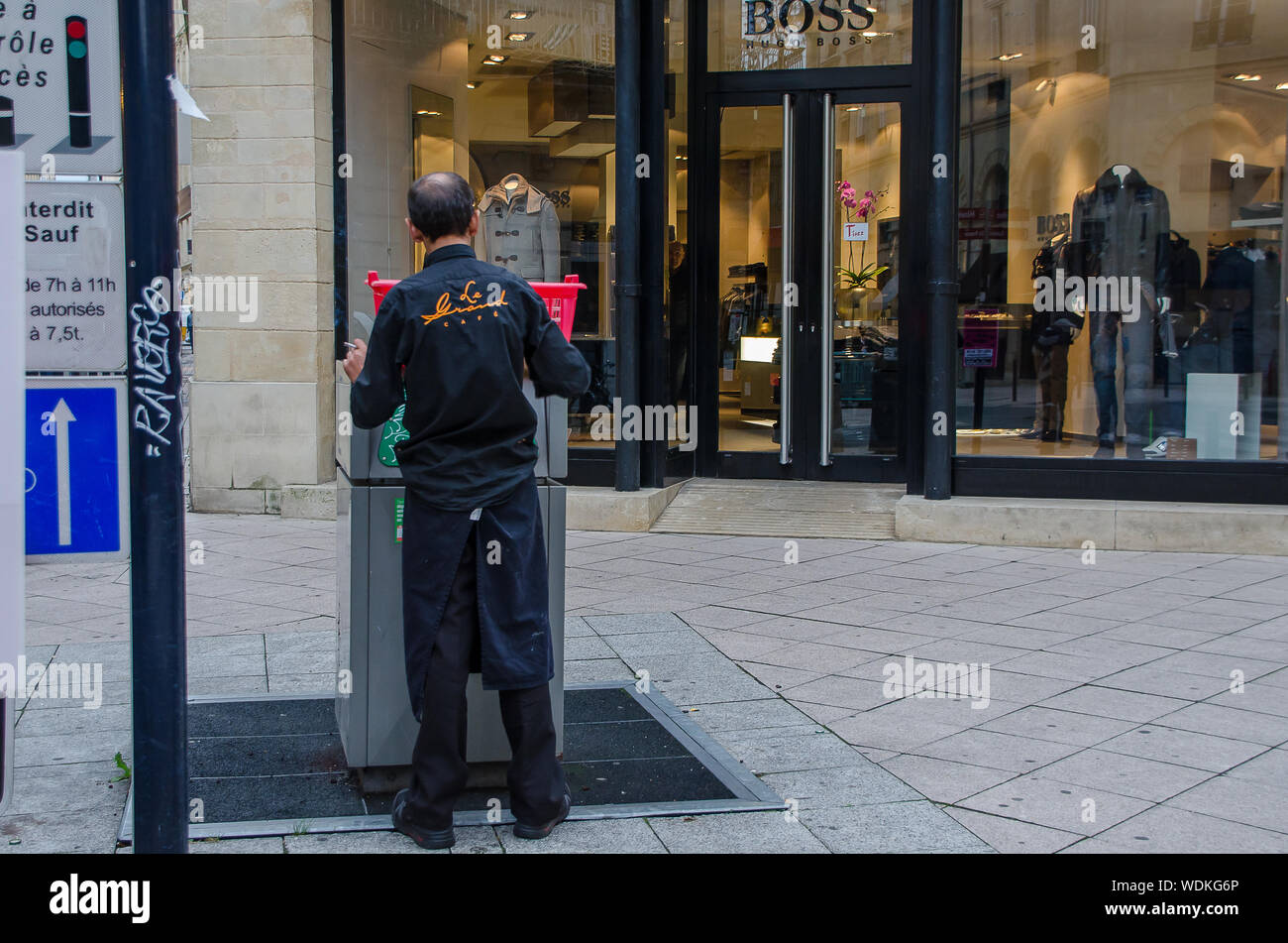 Man throwing garbage in the bin in Bordeaux, France, in September 2013 Stock Photo