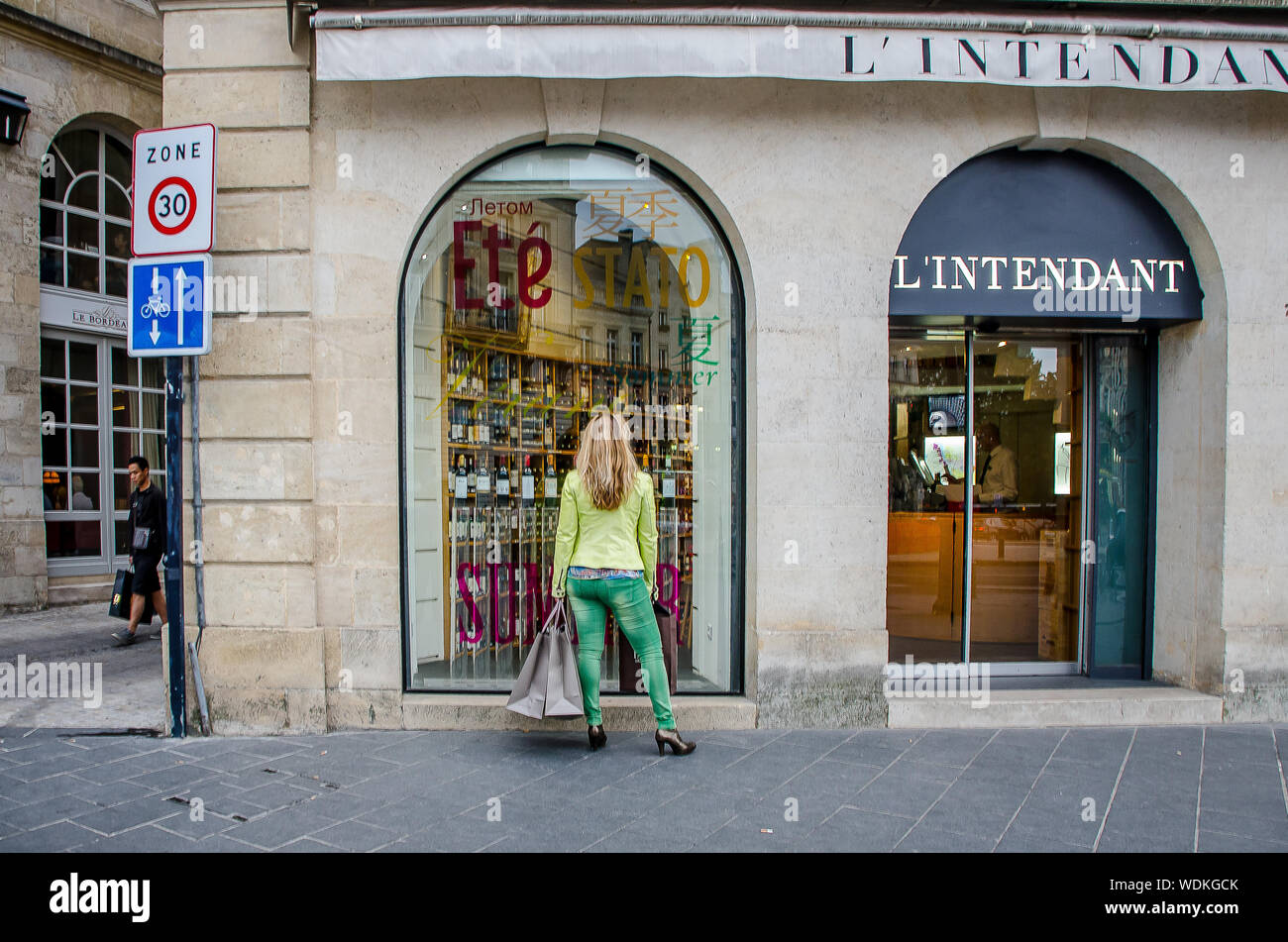 Woman in front of a shop window in the city of Bordeaux in September 2013. France Stock Photo