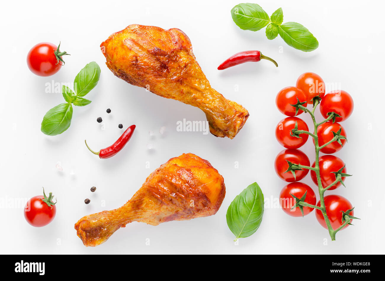 healthy grilled chicken legs with fresh tomato, basilik and chili on white background Stock Photo
