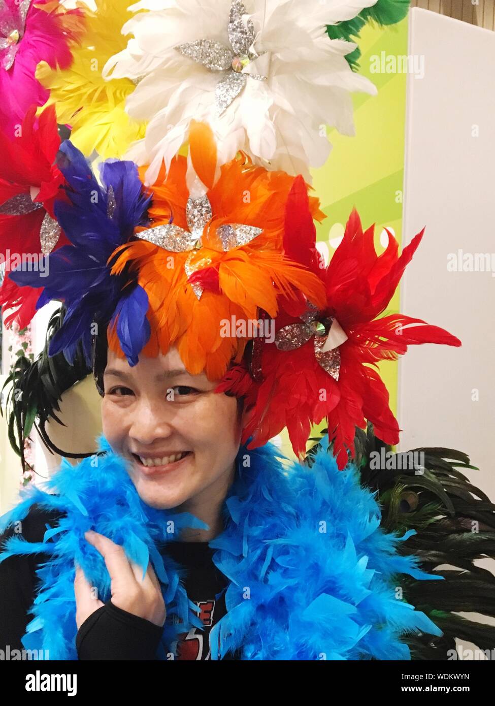 Portrait Of Smiling Woman With Feather Boa Stock Photo