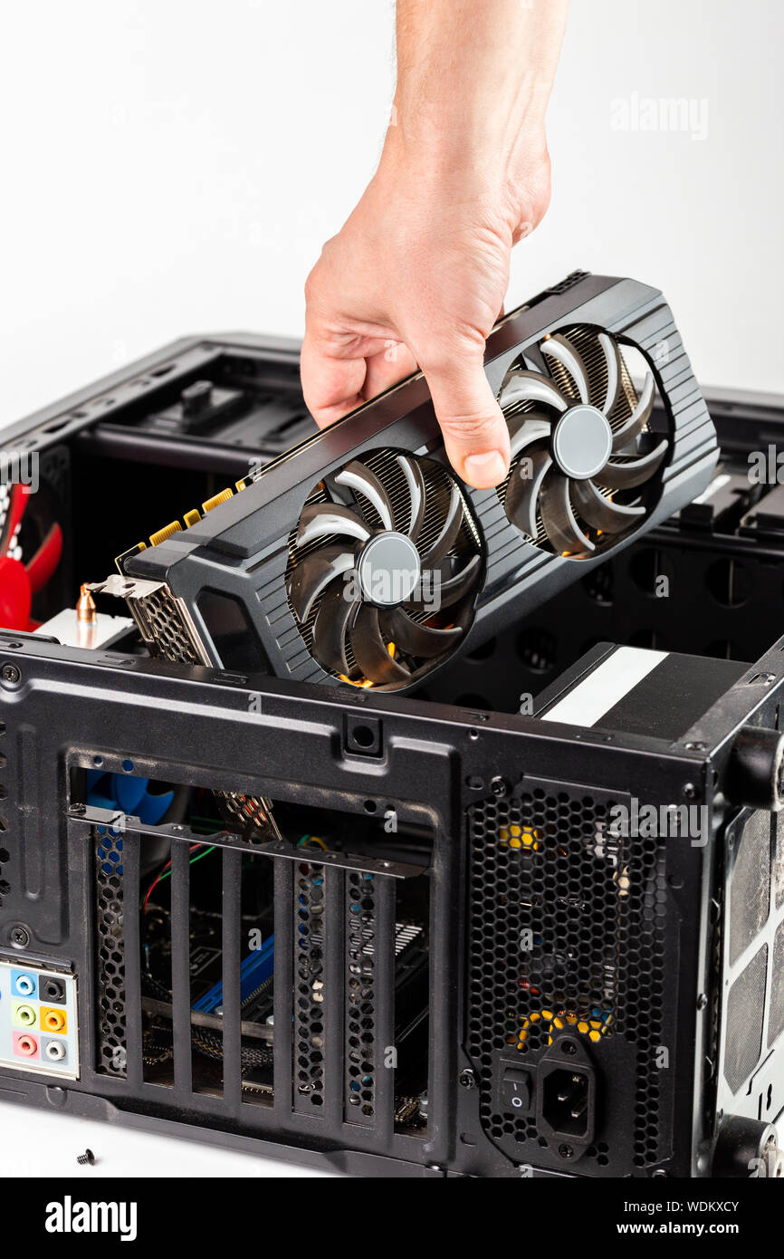 hand plugging a video card while maintenance personal computer hardware with selective focus closeup Stock Photo