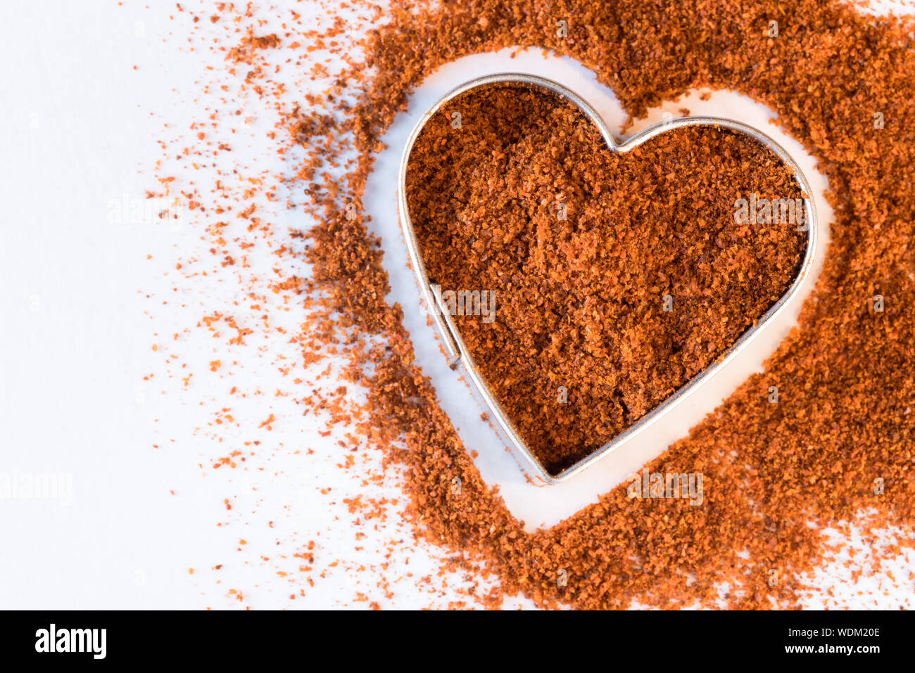 Directly Above View Of Grounded Cayenne In Heart Shaped Container Stock Photo