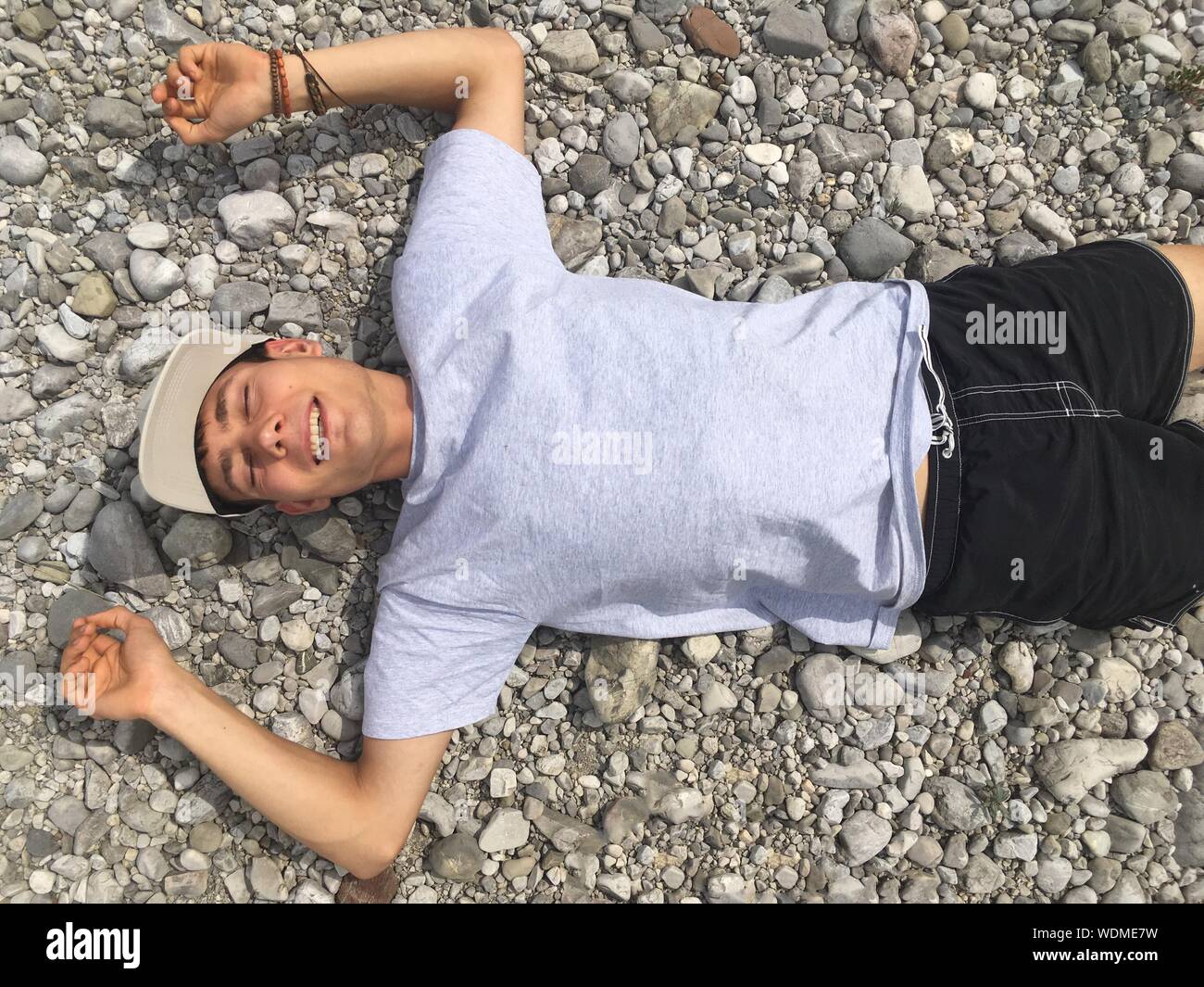 Young Man Lying On Back Outdoors Stock Photo