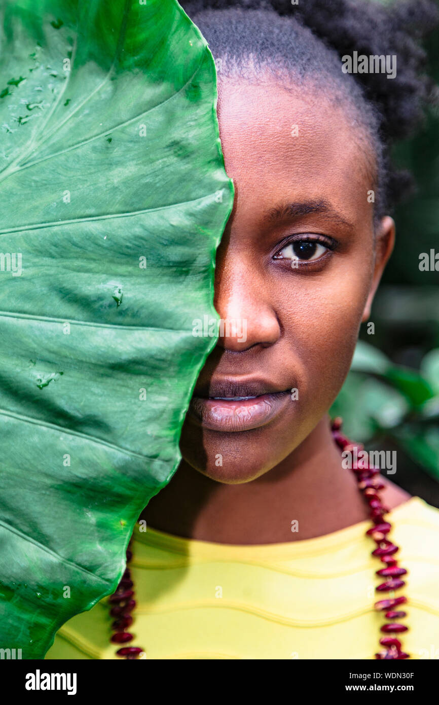 African girl with big leaf covering half of face Stock Photo - Alamy
