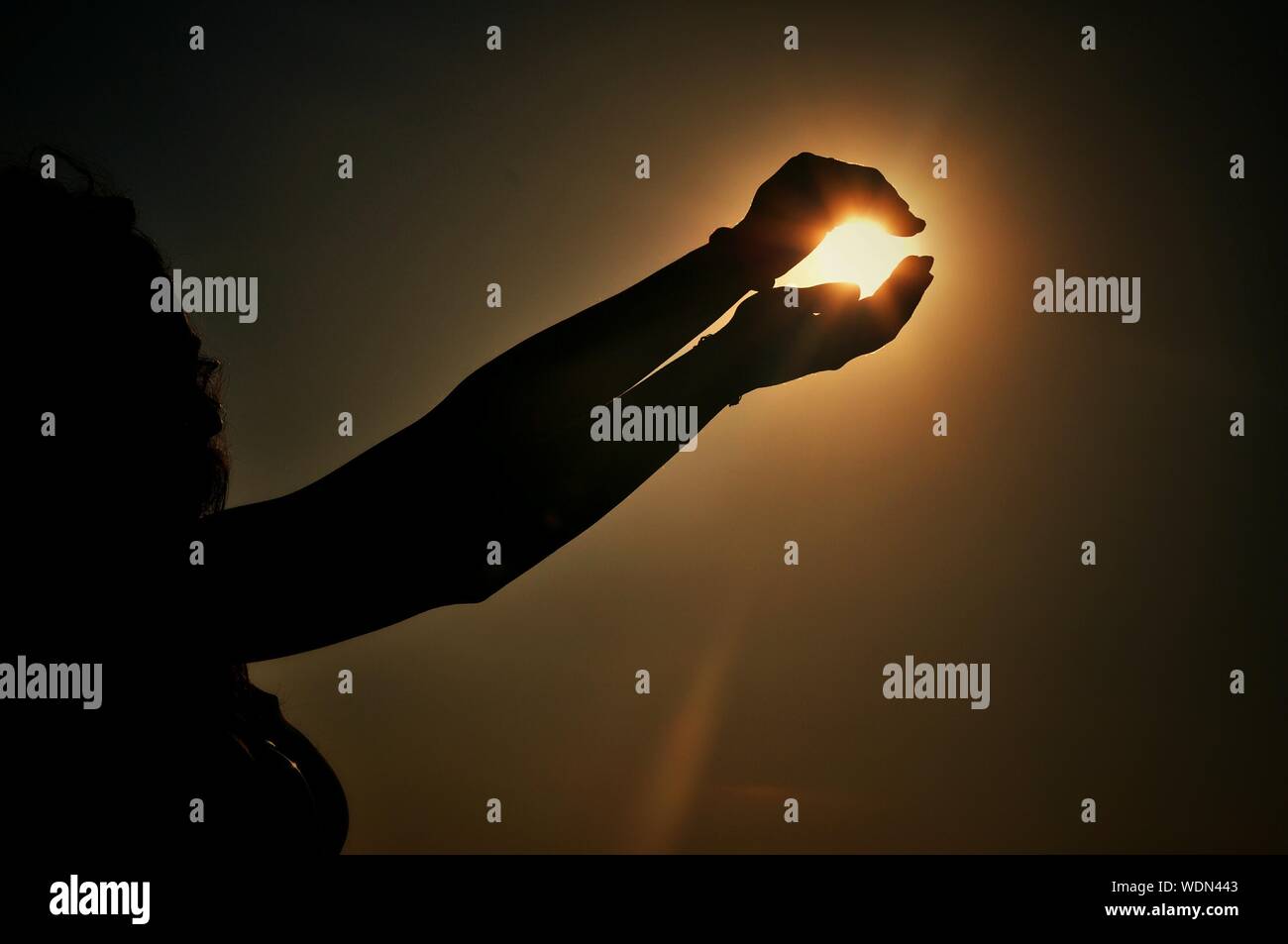 Close-up Of Hands Pretending To Hold Sun Stock Photo