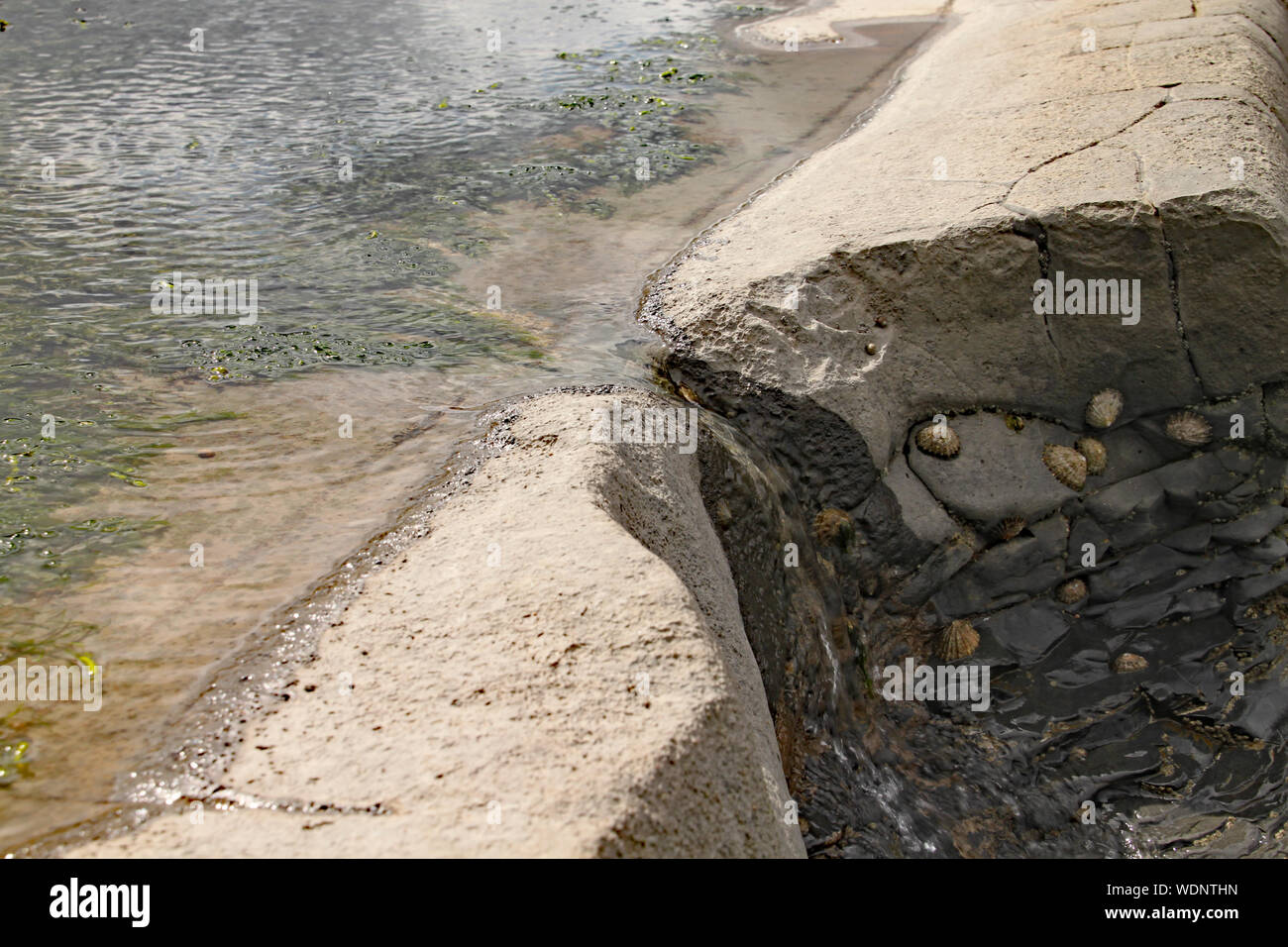 Water trickles down a gap in the rocks caused by millions of years of ...