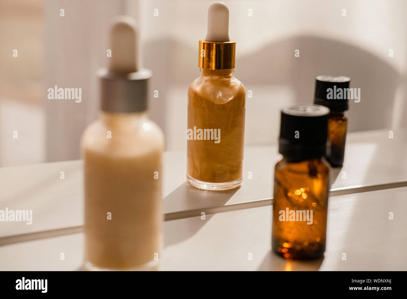 Glass bottles with dropper pipettes. Luminous and luxury gold and white